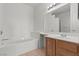 Bright bathroom boasts a soaking tub, tile floor, and wood vanity with sink at 5655 E Sahara Ave # 2044, Las Vegas, NV 89142