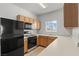 Well-lit kitchen features wood cabinets, black appliances, and tile flooring at 5655 E Sahara Ave # 2044, Las Vegas, NV 89142