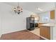 Efficient kitchen space with wooden cabinetry, black appliances, and a dining area featuring a modern chandelier at 5655 E Sahara Ave # 2044, Las Vegas, NV 89142