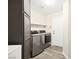 Laundry room with modern washer and dryer units, plus storage cabinet at 5832 Ivy Vine Ct, Las Vegas, NV 89141