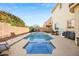 Backyard pool and spa with tiled trim and ample deck space, surrounded by lush landscaping and privacy walls at 5832 Ivy Vine Ct, Las Vegas, NV 89141
