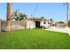 A serene backyard featuring a pool, shaded patio, and verdant artificial grass at 5921 Halifax Ave, Las Vegas, NV 89107