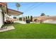 A relaxing backyard featuring a covered patio, grill, and lush artificial grass at 5921 Halifax Ave, Las Vegas, NV 89107