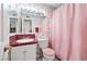 Vintage bathroom with red tile accents, a light-up mirror and a pink shower curtain at 5921 Halifax Ave, Las Vegas, NV 89107