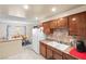 Practical kitchen featuring wood cabinetry, double sink, and white appliances at 5921 Halifax Ave, Las Vegas, NV 89107