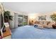 Cozy living room with plush blue carpeting, comfortable seating, and sliding glass doors to the backyard at 5921 Halifax Ave, Las Vegas, NV 89107
