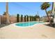 A refreshing pool surrounded by concrete, palm trees, and privacy shrubs at 5921 Halifax Ave, Las Vegas, NV 89107