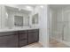 Bright bathroom featuring double sinks, a large mirror, and a glass-enclosed shower at 6150 Foxes Dale St, Las Vegas, NV 89166