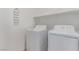 A clean laundry room with a washing machine, dryer, and storage shelves at 6150 Foxes Dale St, Las Vegas, NV 89166