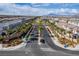 Palm tree lined community entrance showcasing a symmetrical street design and mountain views at 6150 Foxes Dale St, Las Vegas, NV 89166