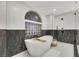 Modern bathroom featuring a soaking tub with black marble and a stylish window at 62 Incline Village Ct, Henderson, NV 89074