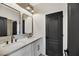 Modern bathroom featuring double sinks, elegant mirrors, and updated lighting fixtures and cabinetry at 62 Incline Village Ct, Henderson, NV 89074