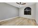 This bedroom features wood-look flooring, an updated ceiling fan, and a large arched window letting in natural light at 62 Incline Village Ct, Henderson, NV 89074