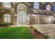 Inviting home featuring manicured front lawn, a three-car garage, and an arched entryway at 62 Incline Village Ct, Henderson, NV 89074
