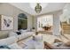Elegant living room with a large window, wood floors, and open access to the dining area and staircase at 62 Incline Village Ct, Henderson, NV 89074