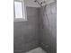 Bathroom featuring gray tiled walls and shower head with a small window at 621 Van Ert Ave, North Las Vegas, NV 89030