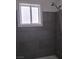 Bathroom featuring gray tiled walls and shower head with a small window at 621 Van Ert Ave, North Las Vegas, NV 89030