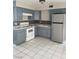 Kitchen featuring white appliances, white tile flooring, and painted cabinets at 621 Van Ert Ave, North Las Vegas, NV 89030