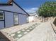 View of the backyard with pavers, gravel, and a blue house at 6215 Don Zarembo Ave, Las Vegas, NV 89108