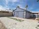View of the backyard with pavers, gravel, and a blue house at 6215 Don Zarembo Ave, Las Vegas, NV 89108