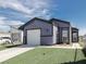 Charming single-story home with an attached garage, front lawn, and a concrete driveway against a partly cloudy blue sky at 6215 Don Zarembo Ave, Las Vegas, NV 89108