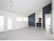 Bright living room with a stone wall with fireplace, large windows, glass patio door, light colored flooring, and chandelier at 6215 Don Zarembo Ave, Las Vegas, NV 89108