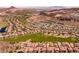An aerial perspective of a community with mountain views, golf courses, and desert landscaping at 63 Via Di Mello, Henderson, NV 89011
