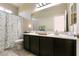 Well-lit bathroom with dual sinks, decorative mirror, and tiled floor at 63 Via Di Mello, Henderson, NV 89011
