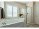 Bathroom with a shower and a soaking tub near a window with shutters at 63 Via Di Mello, Henderson, NV 89011