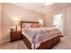 Bedroom with a bed with storage, matching nightstands, and view into the bathroom at 63 Via Di Mello, Henderson, NV 89011