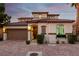 Inviting two-story home features a Spanish-style roof, lush landscaping, and an attached two-car garage at 63 Via Di Mello, Henderson, NV 89011