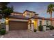 Beautiful two-story home featuring a Spanish tile roof, lush landscaping, and a spacious two-car garage at 63 Via Di Mello, Henderson, NV 89011