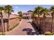 Beautiful two-story home with a desert landscape, brick-paved driveway, and lush palm trees at 63 Via Di Mello, Henderson, NV 89011
