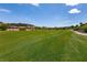 A panoramic view of a pristine golf course with surrounding desert landscape and blue sky at 63 Via Di Mello, Henderson, NV 89011