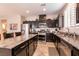 Kitchen with dark cabinets, granite countertops, stainless steel appliances, and large island at 63 Via Di Mello, Henderson, NV 89011