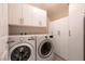 Functional laundry room with washer, dryer, and ample storage cabinets at 63 Via Di Mello, Henderson, NV 89011