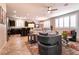 Open concept living space featuring an accent rug, a sofa, a ceiling fan, and natural light from shuttered windows at 63 Via Di Mello, Henderson, NV 89011