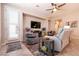 Contemporary living room with a fan, TV, and access to the front door, seamlessly connecting to the outdoors at 63 Via Di Mello, Henderson, NV 89011