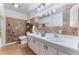 Bathroom featuring double sinks, white cabinetry, and neutral tile work at 6931 Leon Ave, Las Vegas, NV 89131