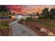 Charming single-story brick home featuring a welcoming walkway and meticulously landscaped front yard at sunset at 6931 Leon Ave, Las Vegas, NV 89131