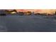 Expansive lot provides ample space for development, featuring various structures and colorful sunset backdrop at 6931 Leon Ave, Las Vegas, NV 89131