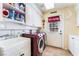 Well-lit laundry room with modern washer and dryer units and ample shelving at 6931 Leon Ave, Las Vegas, NV 89131