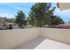 Balcony overlooking tile rooftops and lush trees against a clear blue sky, a serene outdoor space at 7012 Bright Springs Ct, Las Vegas, NV 89113