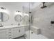 Modern bathroom featuring double sinks, white cabinets and a glass-enclosed shower with a built-in bench at 7012 Bright Springs Ct, Las Vegas, NV 89113