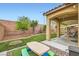 Relaxing backyard with a picnic table on turf, a water feature, and a covered patio at 7497 Alamo Ranch Ave, Las Vegas, NV 89179