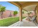 Inviting covered patio with outdoor seating overlooking the serene backyard with water fountain feature at 7497 Alamo Ranch Ave, Las Vegas, NV 89179