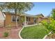 Lush backyard featuring a covered patio and artificial turf, perfect for outdoor entertaining at 7497 Alamo Ranch Ave, Las Vegas, NV 89179