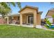 Charming backyard with covered patio, artificial turf, and sliding glass doors to the home at 7497 Alamo Ranch Ave, Las Vegas, NV 89179