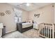 Cozy bedroom with a daybed, crib, ceiling fan and natural light at 7497 Alamo Ranch Ave, Las Vegas, NV 89179