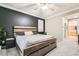 This bedroom has a rustic wooden bedframe, a dark accent wall and access to the bathroom at 7497 Alamo Ranch Ave, Las Vegas, NV 89179
